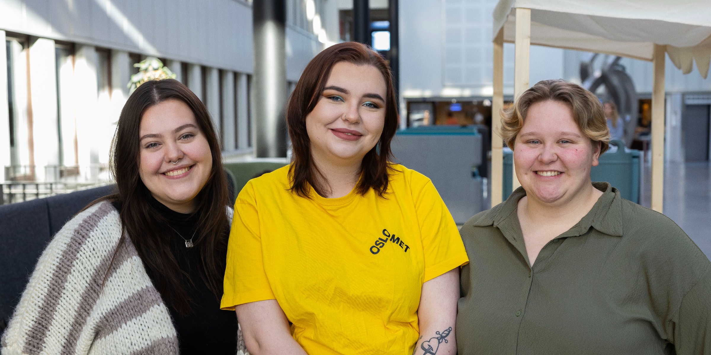 Three campus hosts smiling to the camera.