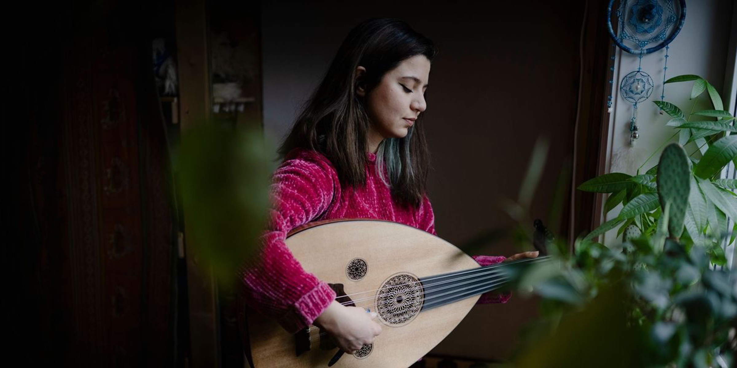 Kvinne spiller på et strengeinstrument.