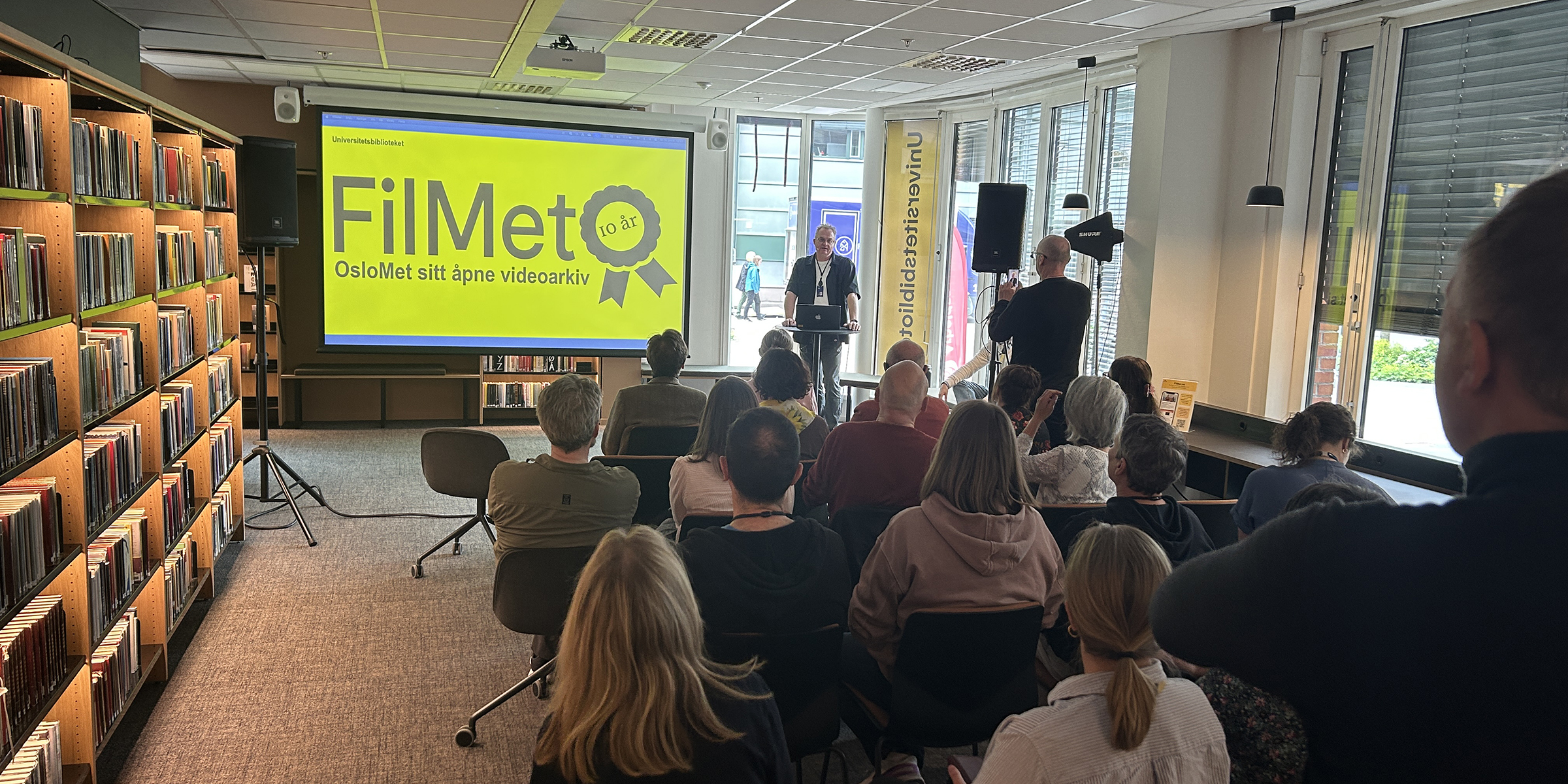 Medieseksjonen presenterer FilMet for en gruppe sittende mennesker i biblioteket.