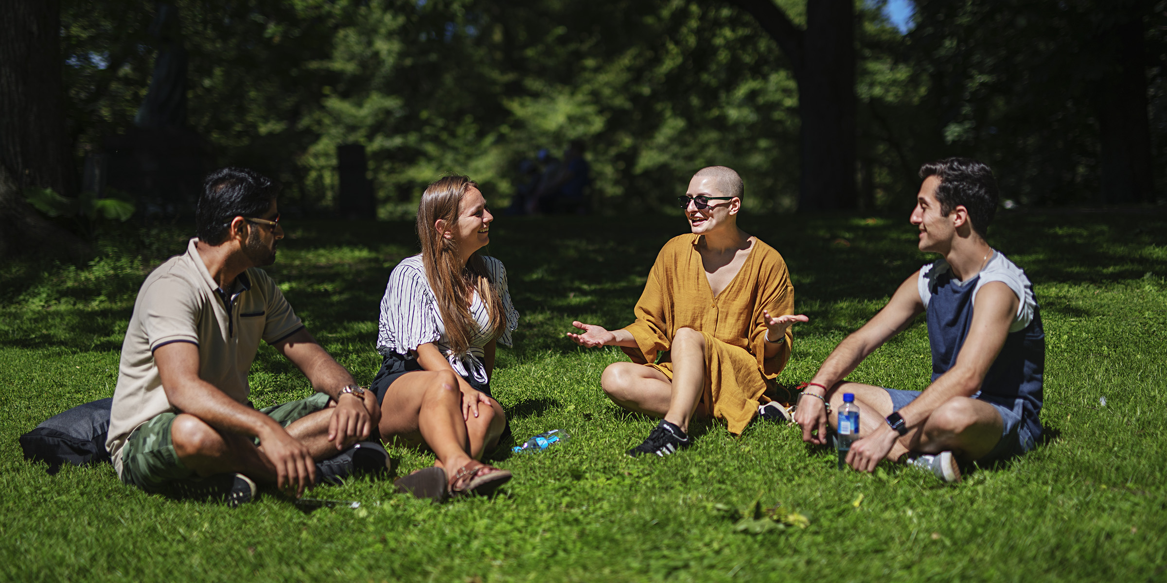 Studenter som sitter og prater sammen i parken.