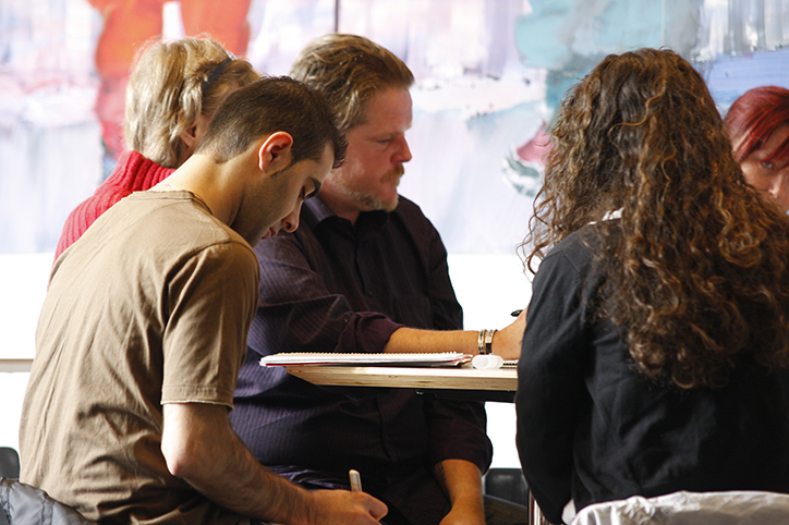 Studenter som sitter rundt et bord og jobber.