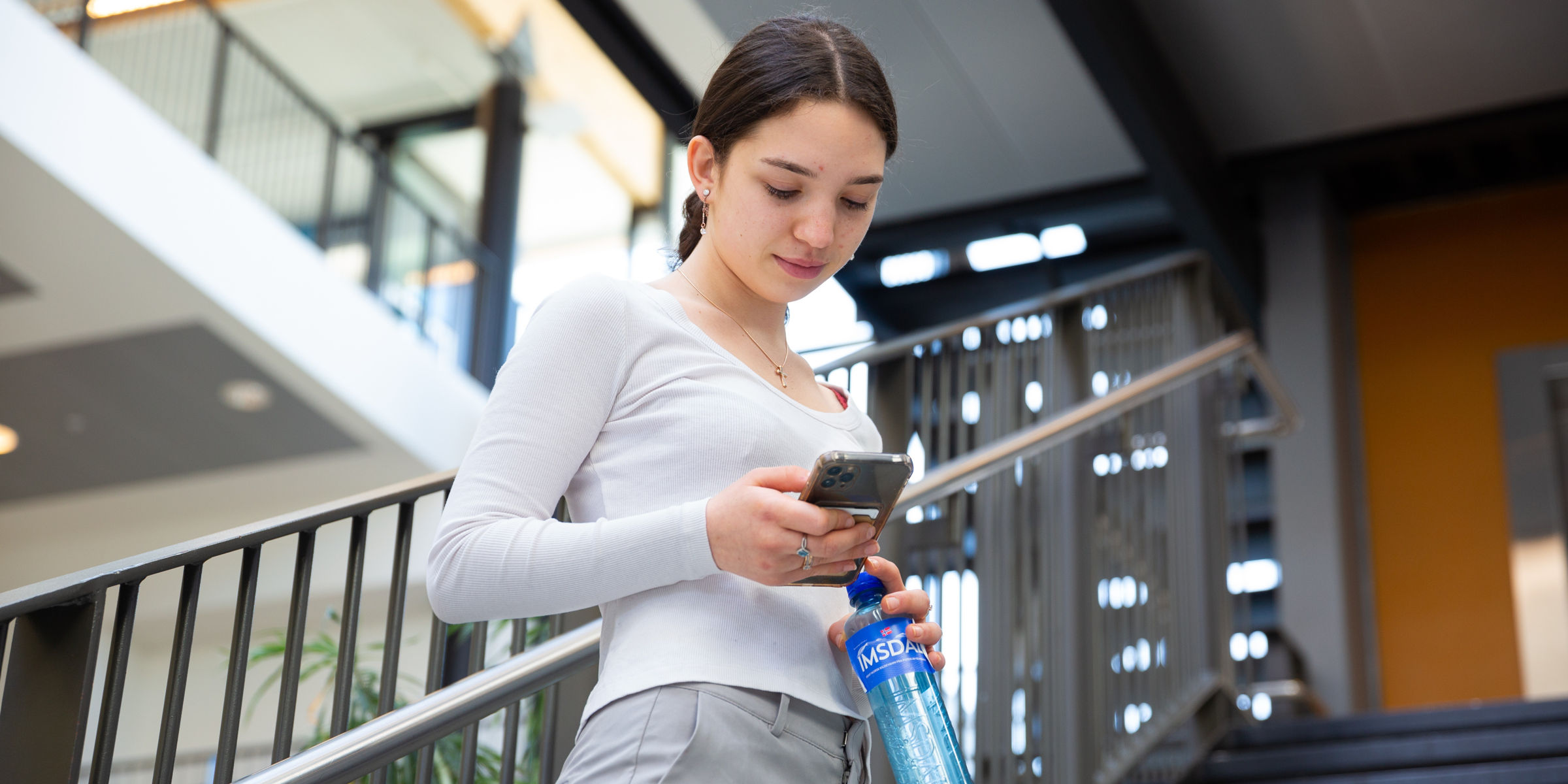 Student ser på mobiltelefonen sin.