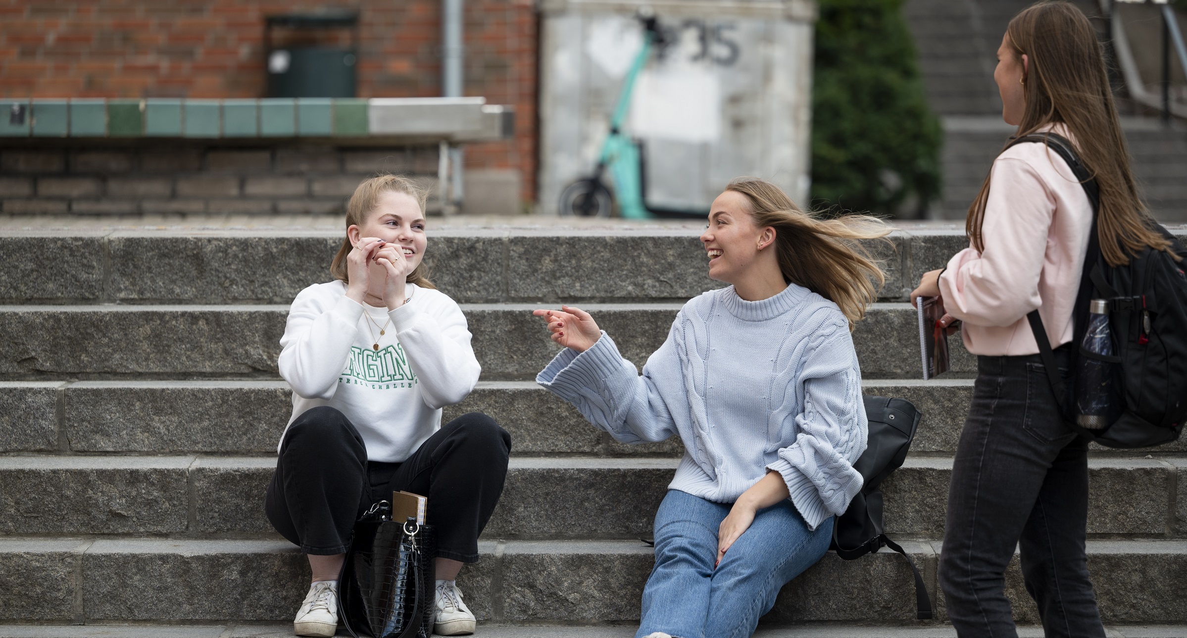 Three students sitting at the stairs talking. Foto: Skjalg Bøhmer Vold