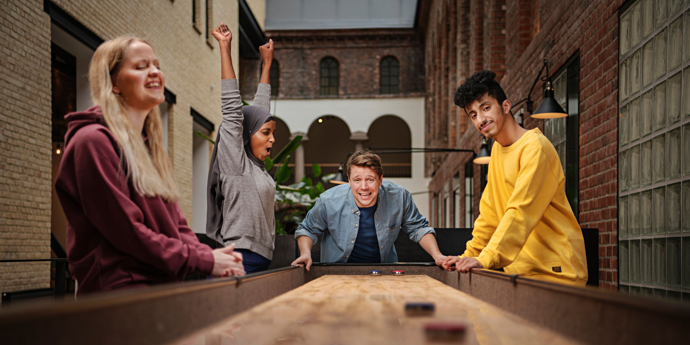 Fire OsloMet-studenter spiller shuffleboard i Pilestredet 52.
