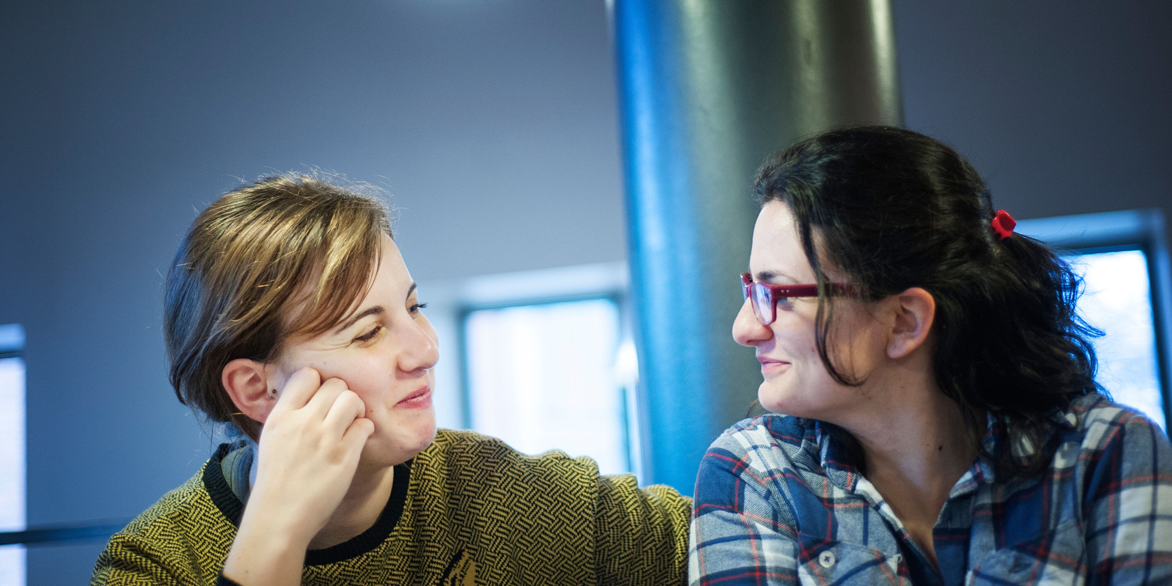 To OsloMet-studenter ser på hverandre og smiler.