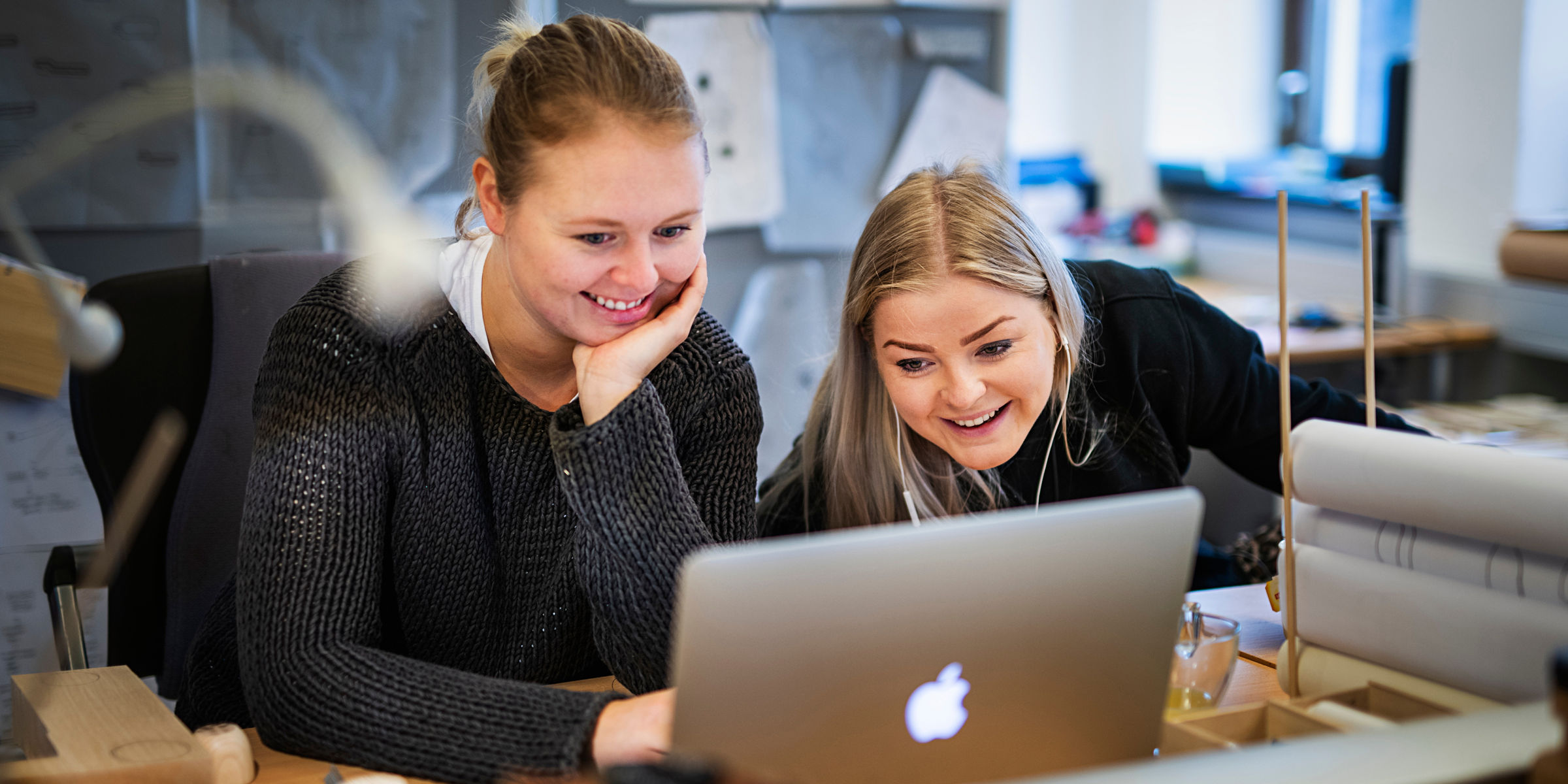 To smilende studenter ser sammen på en PC