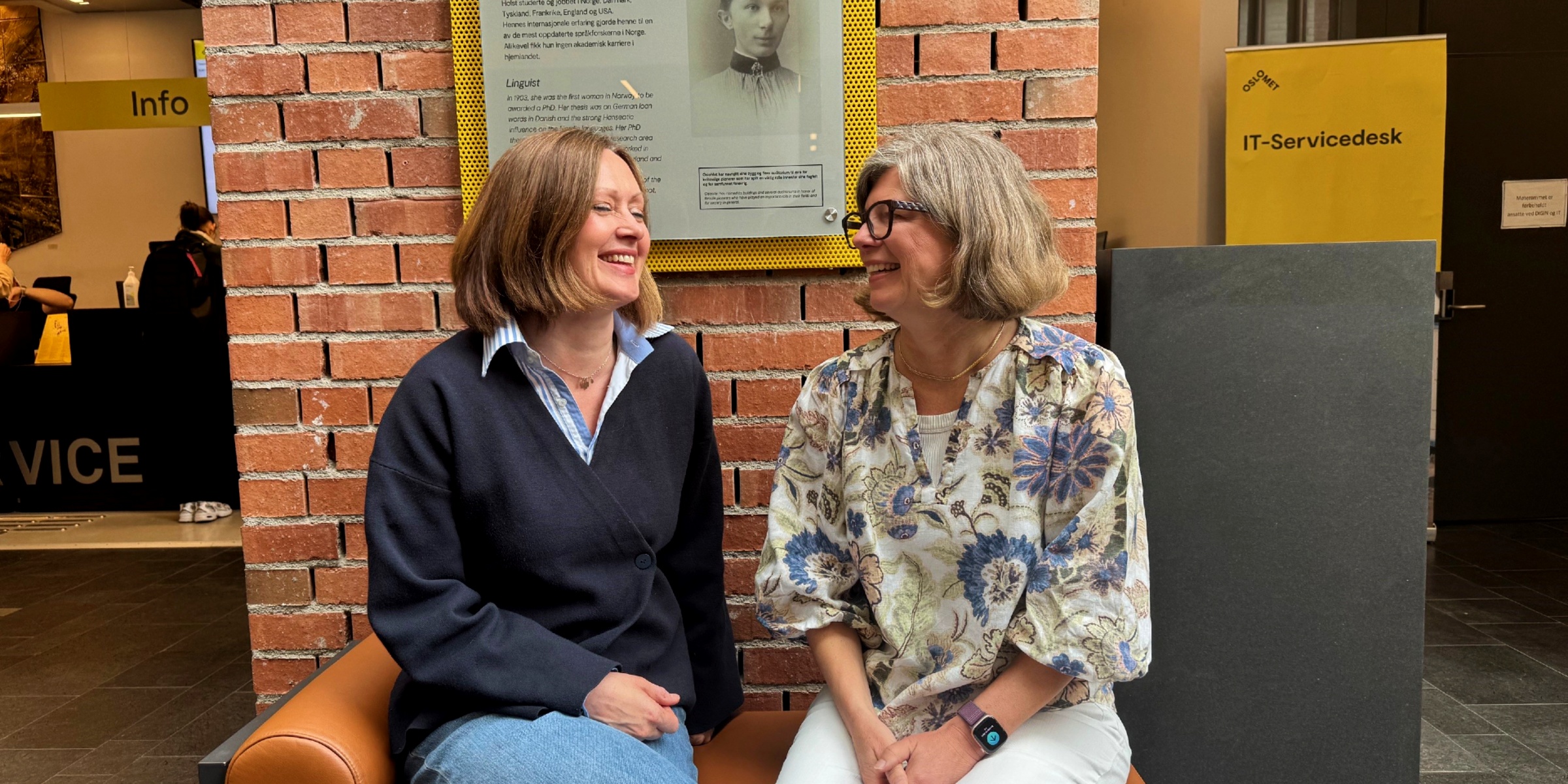 Mira Aaboen Sletten og Tanja Storsul sitter smilende på en benk