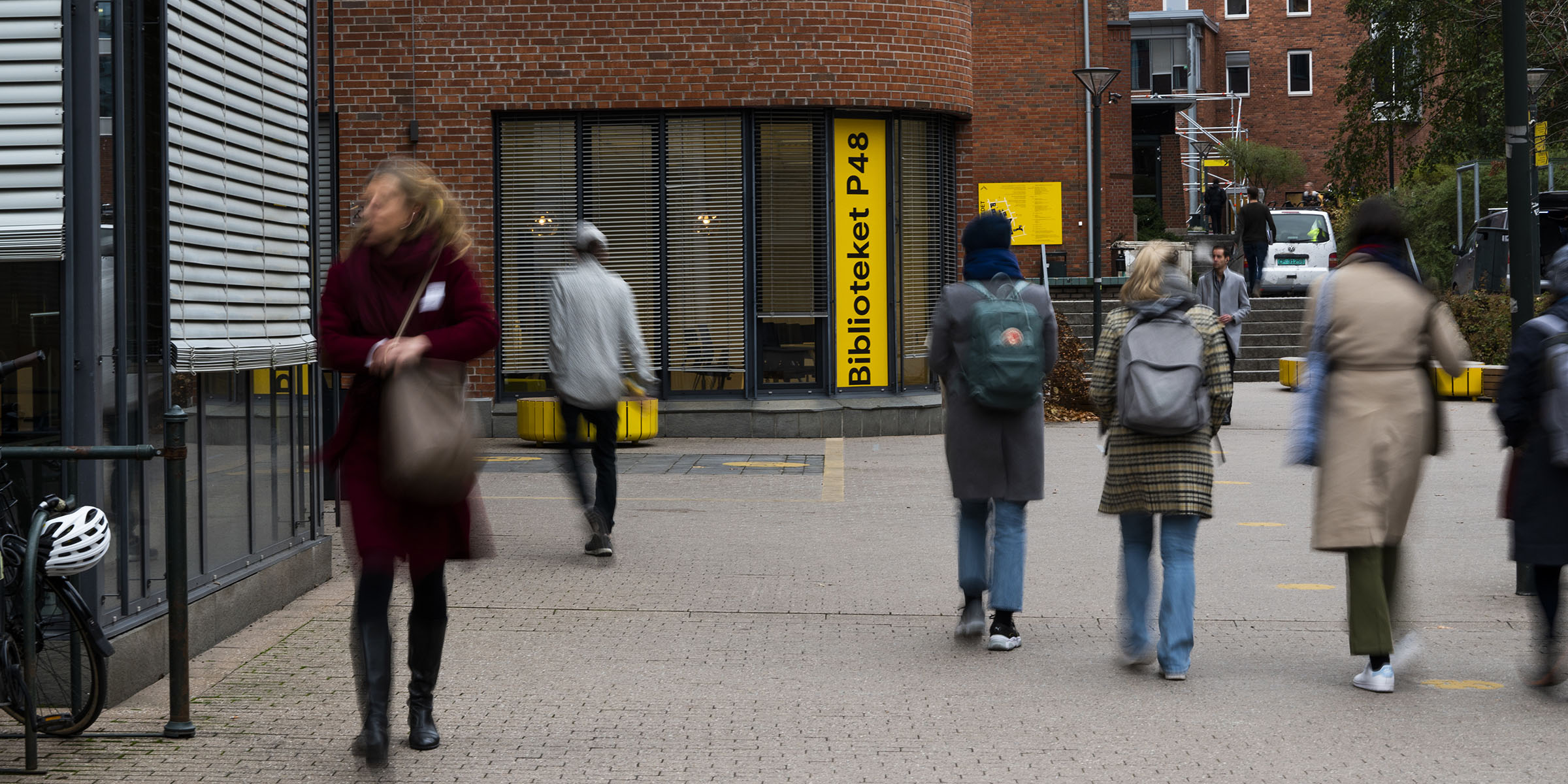 Blurry image of people walking outside at the Pilestredet campus.