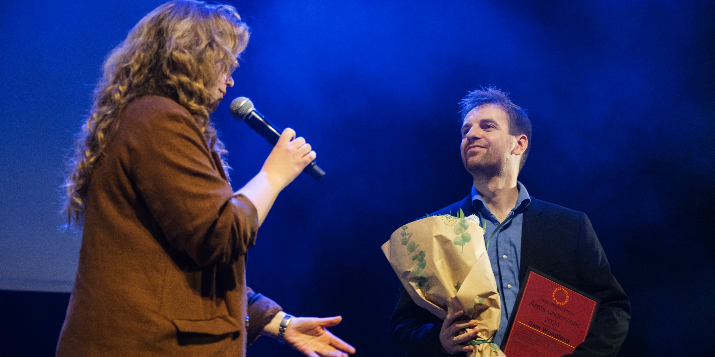 Sam Woodford receives the award from the leader of the Student Parliament, Amalie Fadler Opdal.