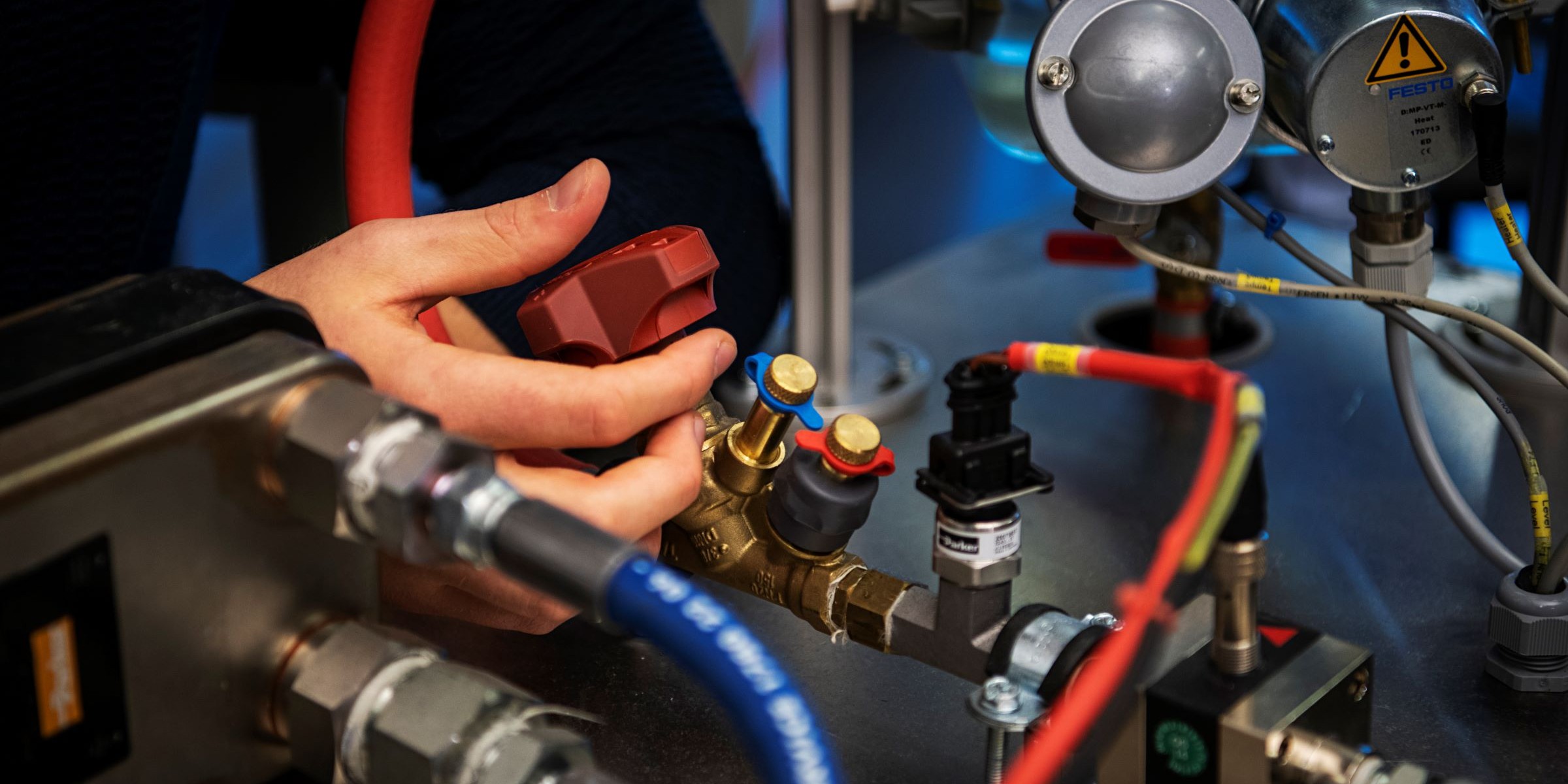Close up photo of hands working with mechanical equipment.