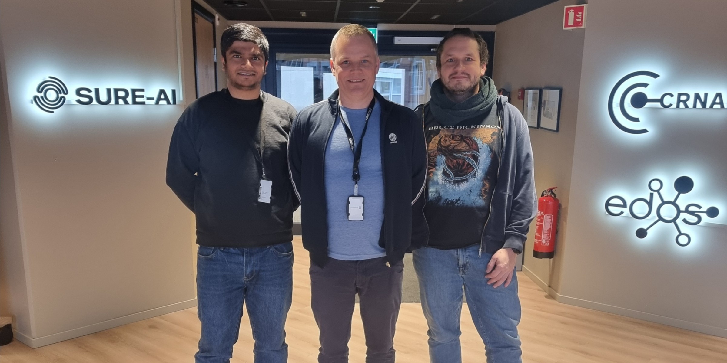 Bilde av stipendiat Sushant Gautam ved OsloMet, direktør ved SimulaMet Klas Pettersen og OsloMet-professor Michael Riegler, som står sammen i et kontorlokale.