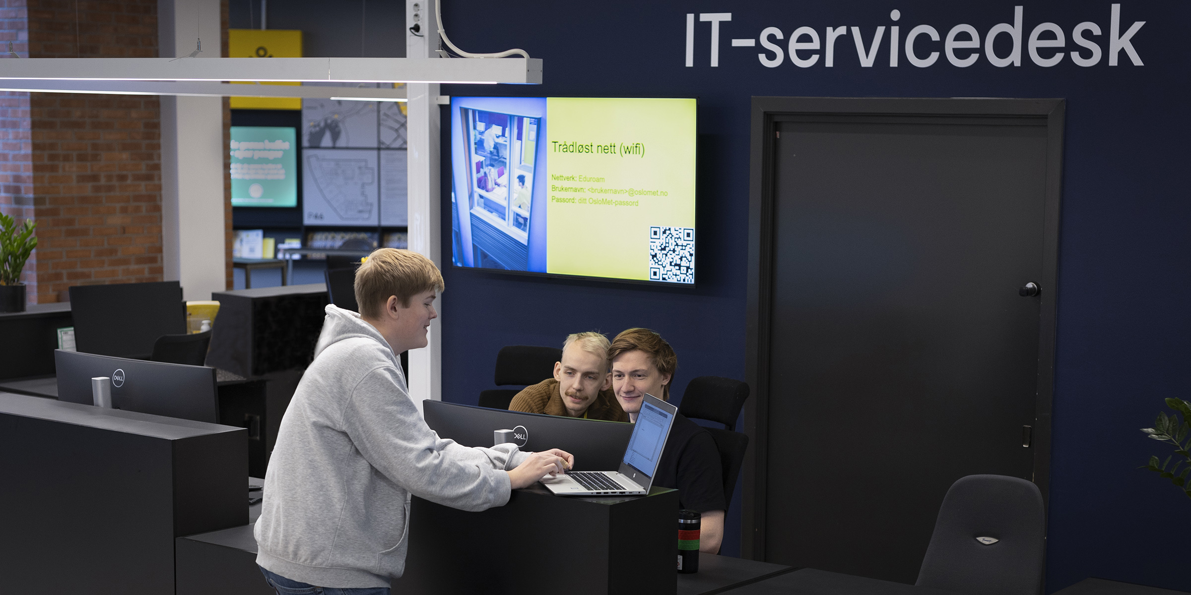 Reception area where two IT-assistants provide service to colleagues.